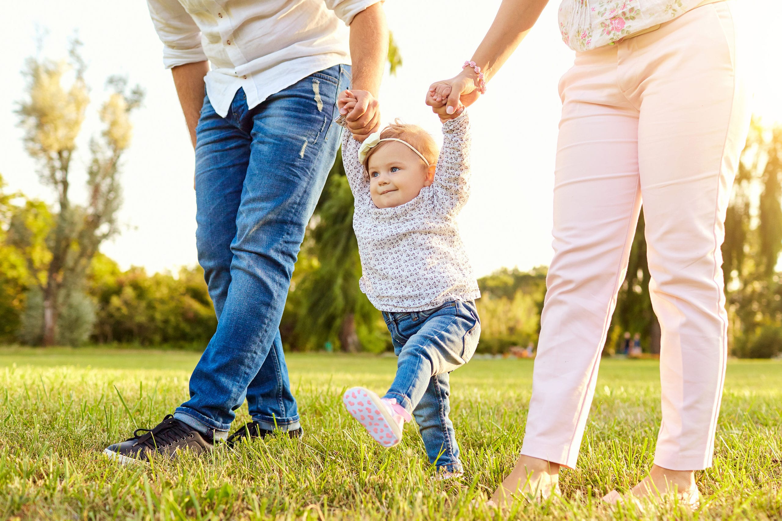 The first steps of the baby. A happy family.