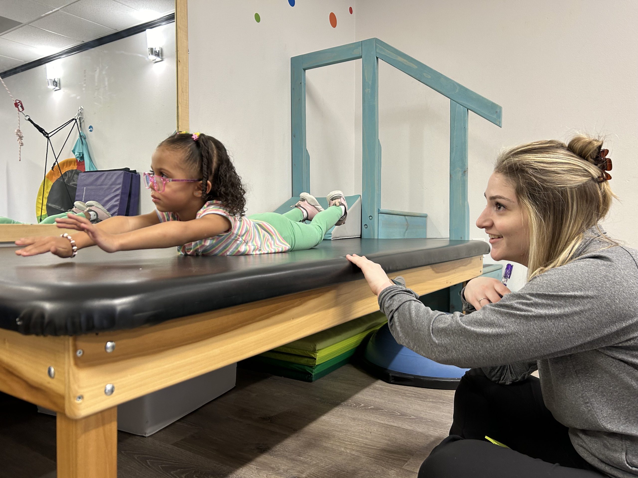 Child and Physical therapist on a plank
