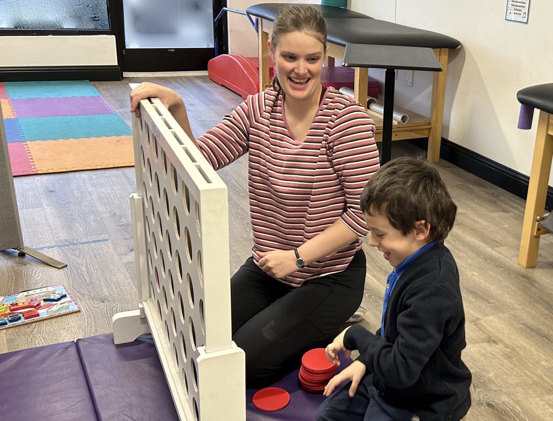 Child and therapist playing connect four